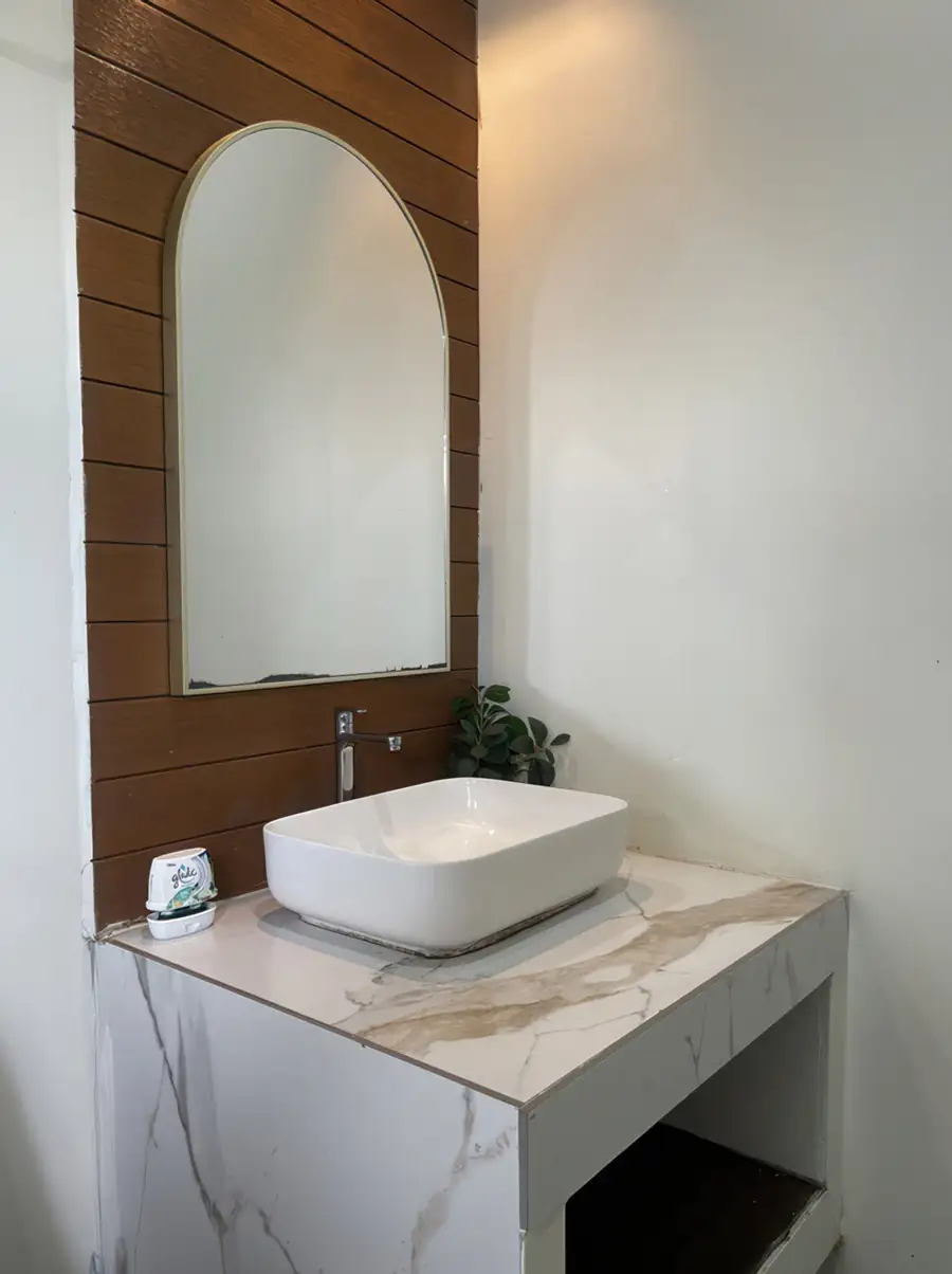 Glass-enclosed electric shower in the modern white bathroom at Dayang Resort Semporna.