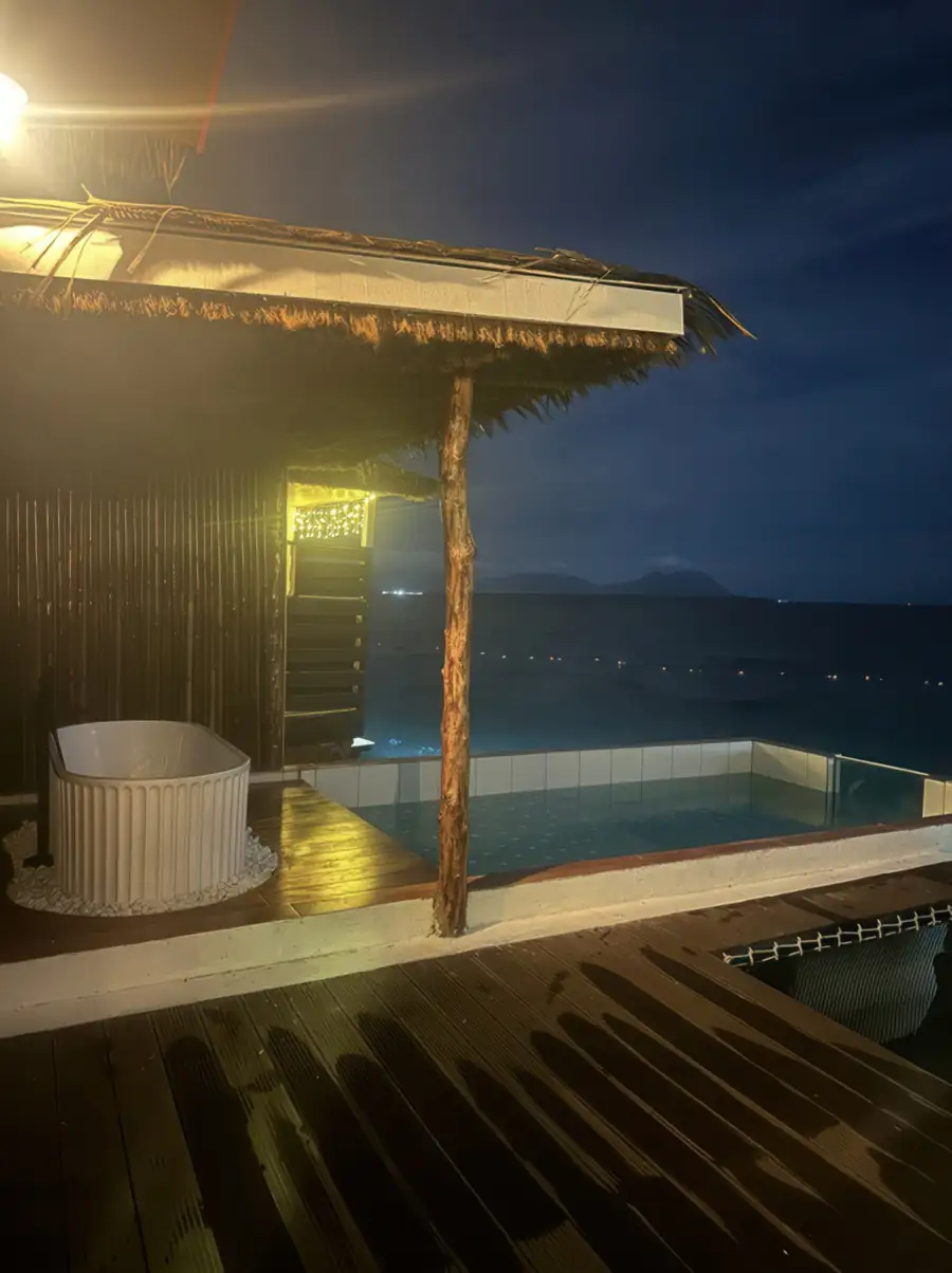 Infinity pool deck with sun loungers at Dayang Resort Semporna overlooking the Celebes Sea.