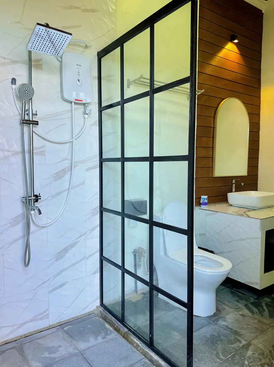 Minimalist white vanity bathroom at Dayang Resort Semporna with round mirror and clean finishes.