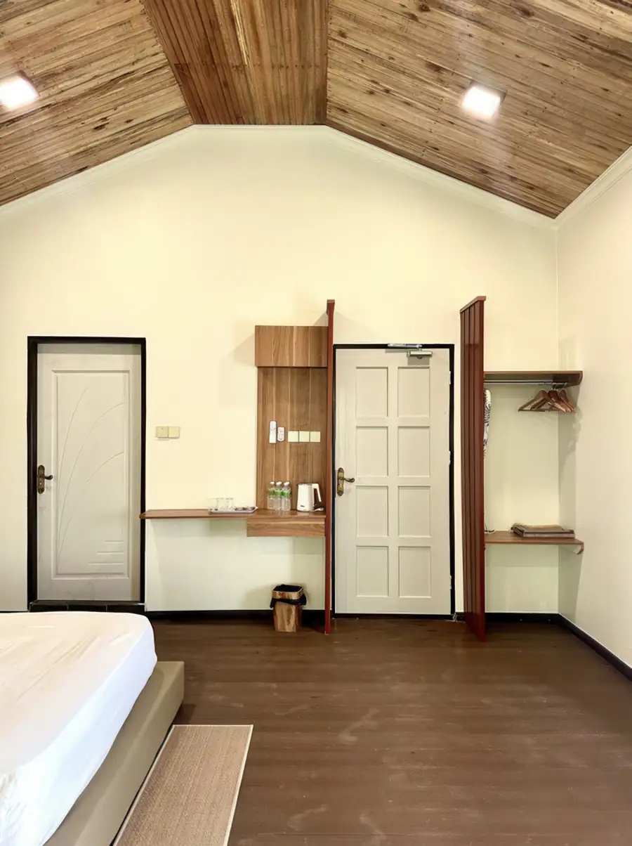 Modern white room vanity area at Dayang Resort Semporna with round mirror and desk.