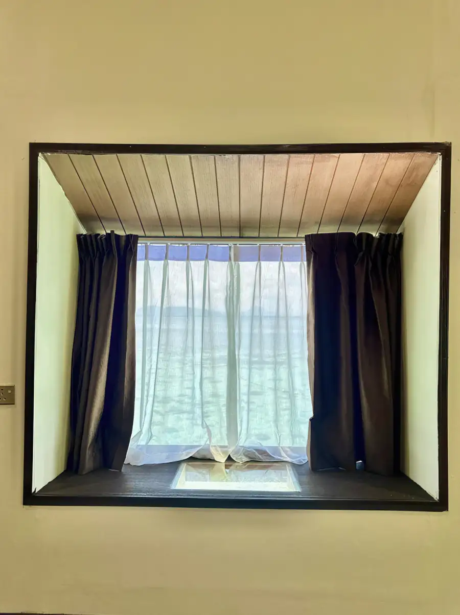 Ocean view framed by the window of a white room at Dayang Resort Semporna.