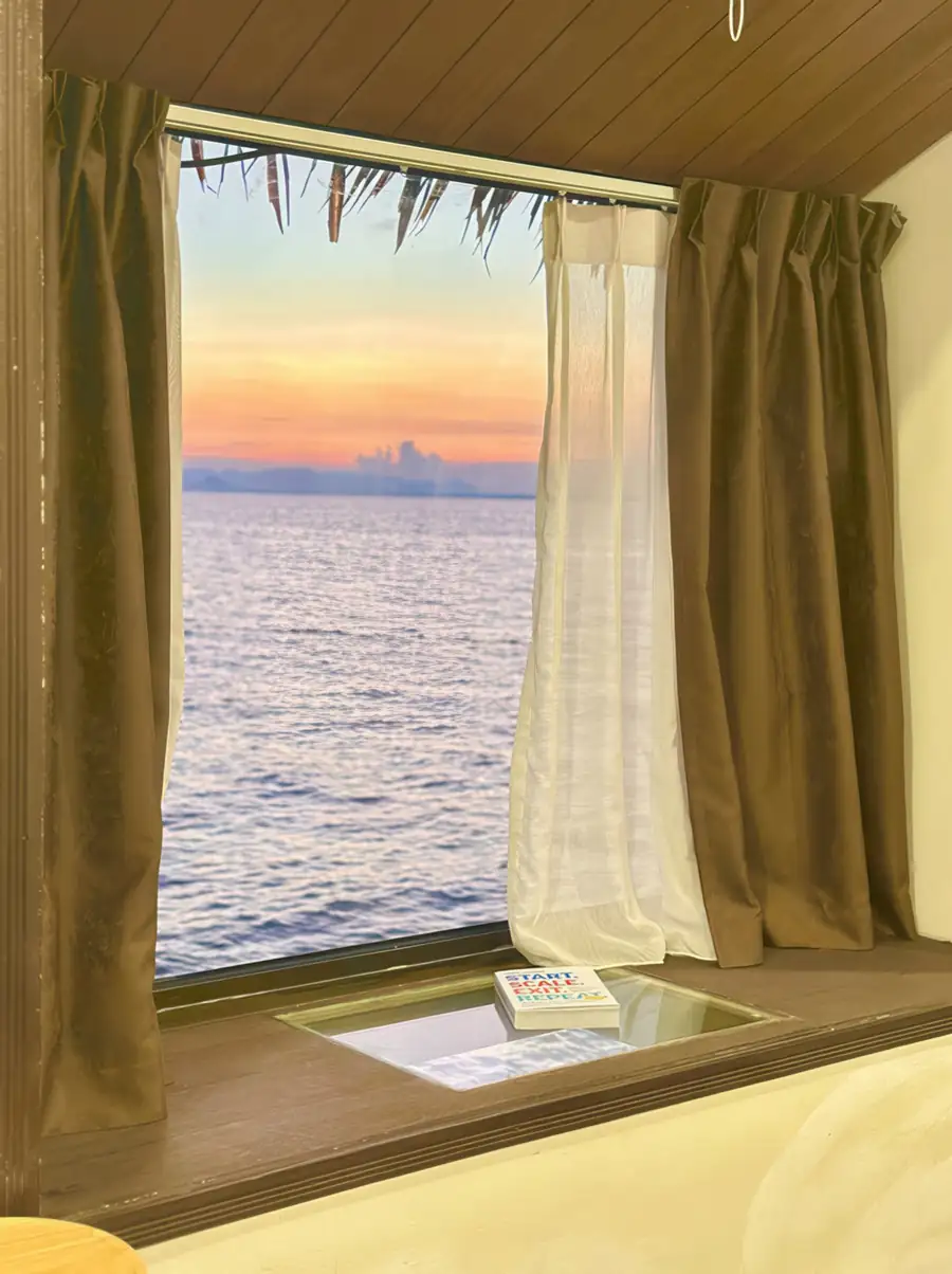 Sunset sea view framed by the bedroom window at Dayang Resort Semporna.
