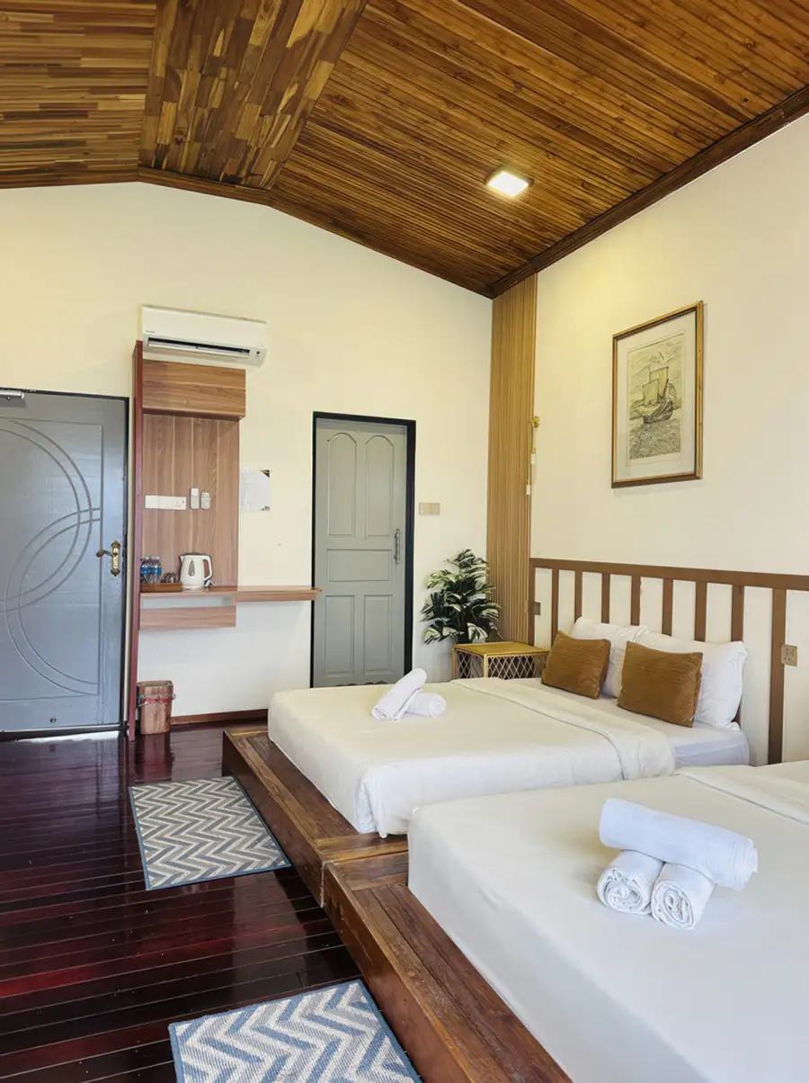 Twin bed room overlooking the water at Dayang Resort Semporna with ocean views through the balcony doors.
