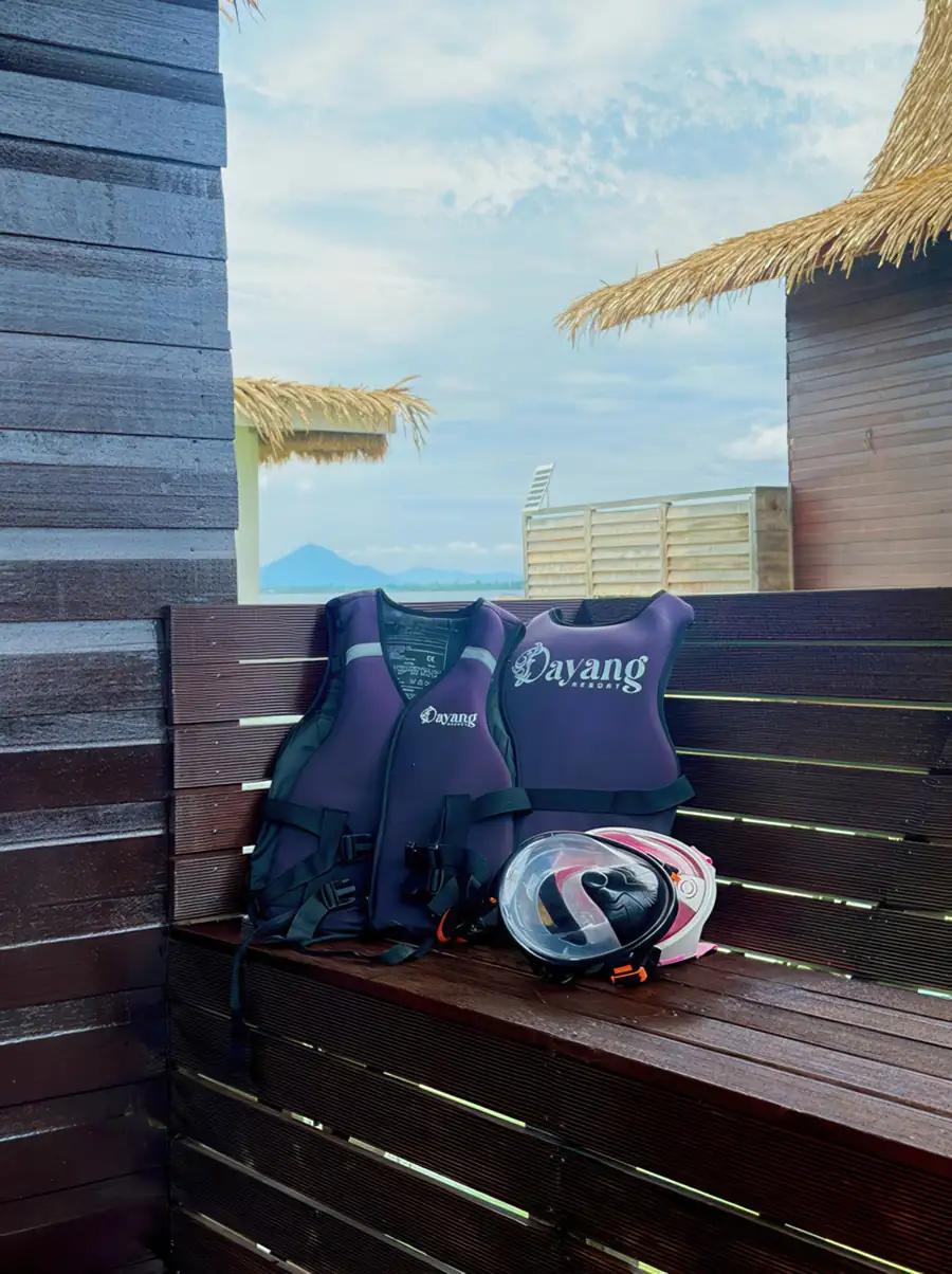 Private balcony bench at Dayang Resort holding life jackets and snorkeling gear. Prepare to explore crystal-clear waters and watch tropical fishes dance below this unique Semporna retreat.